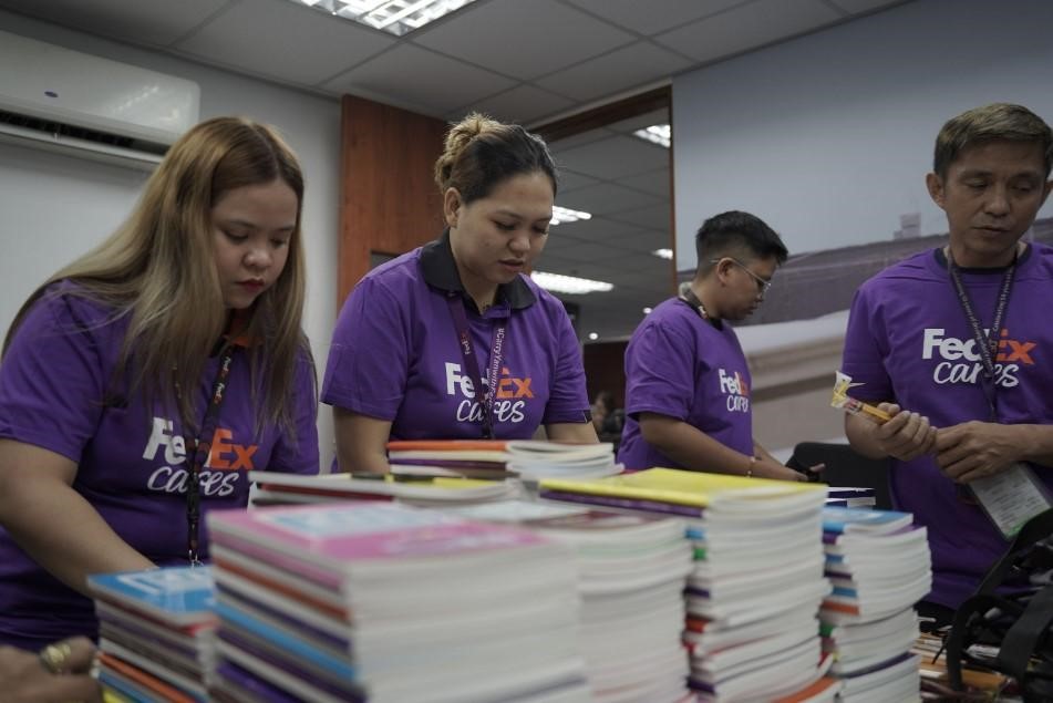 20 FedEx volunteers preparing school bags filled with essential supplies, equipping public school, 