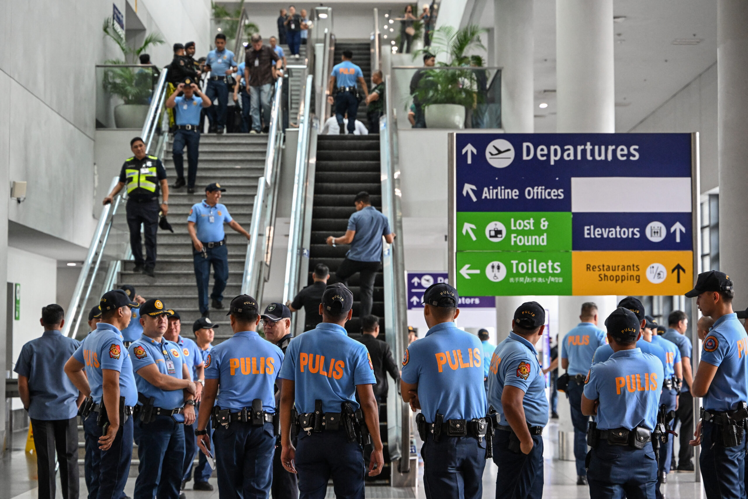 olicemen gather as they wait for the arrival of former Philippine president Rodrigo Duterte at Ninoy Aquino International Airport